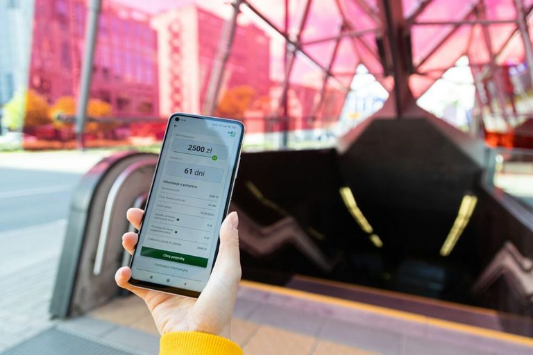 osoba ktora trzyma telefon w trakcie pożyczki dla bezrobotnych